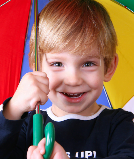 Image of boy holding multicolour umbrella